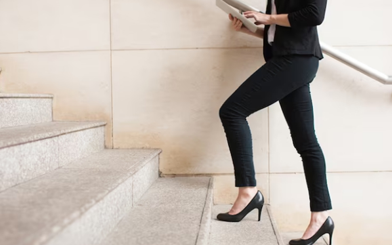 businesswoman walking upstairs and using a touchpad