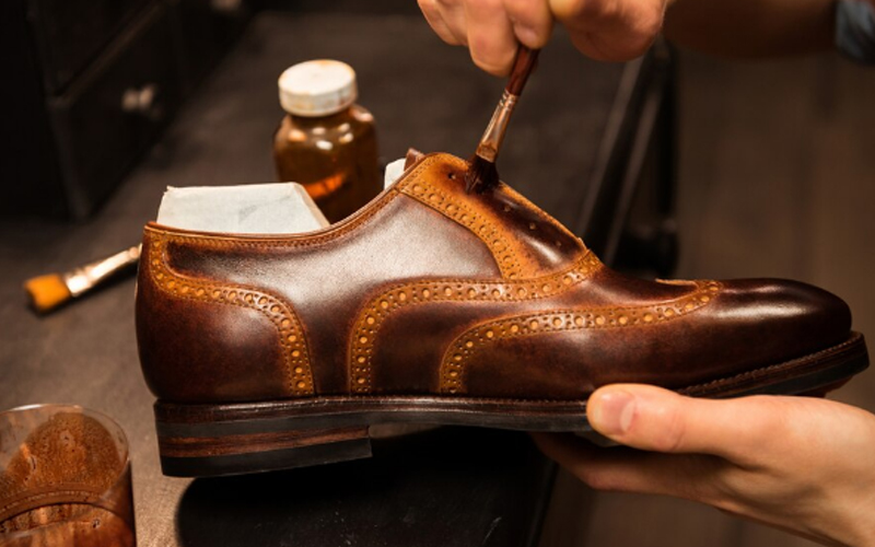 a shoemaker making a leather shoe