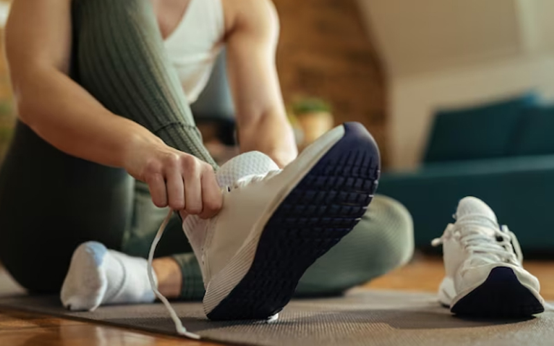 a woman putting on sneakers