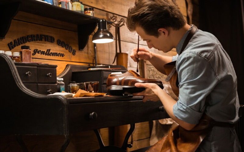 a shoemaker making a shoe in his workshop