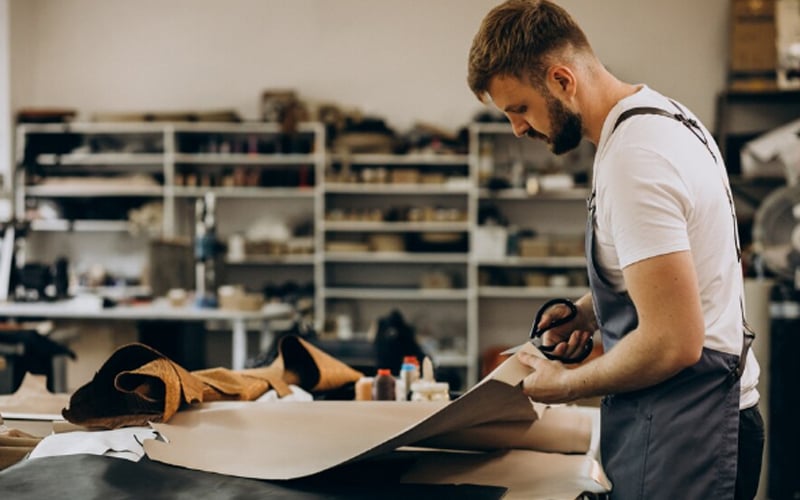 a man tailor working with leather fabric