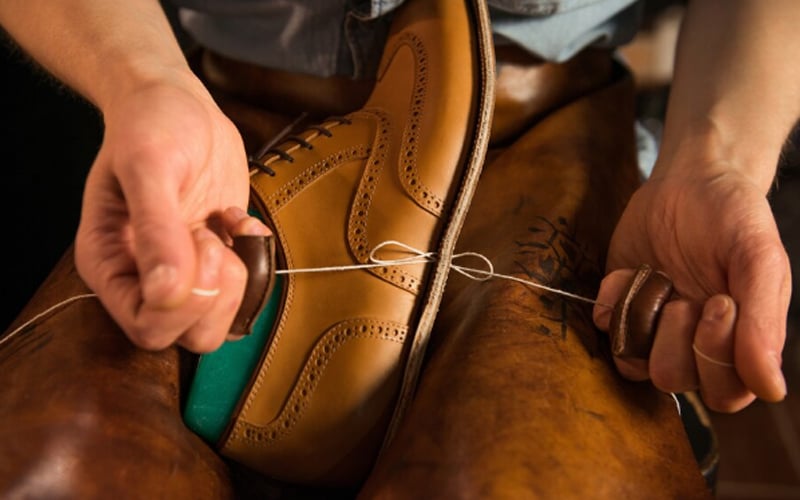shoemaker sewing a shoe